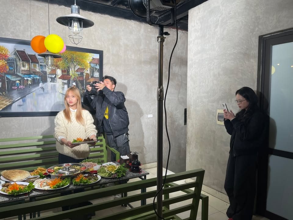 Đội VNTAY quay video giới thiệu mâm món ăn tại nhà hàng, người dẫn cầm đĩa món trước máy quay