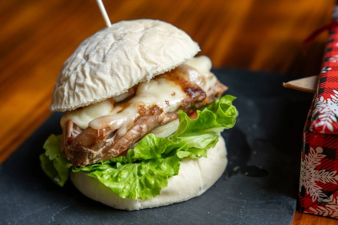 Ảnh cận burger thịt nướng phô mai tan chảy, rau xà lách, bánh mì trắng